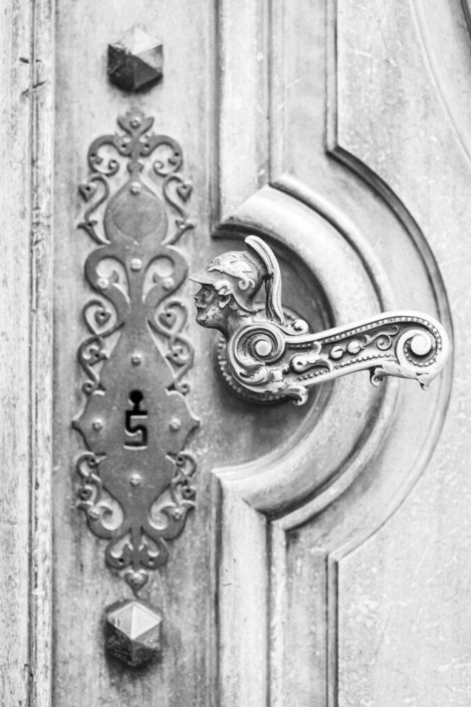 Poignée casquée sur porte ancienne, Vieille Ville Genève, photographie noir et blanc grain Ilford HP5